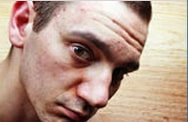 Close-up of a man looking intently at the camera with a serious expression.