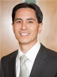 Man in suit with a neutral background.