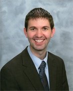 Smiling man in suit and tie.
